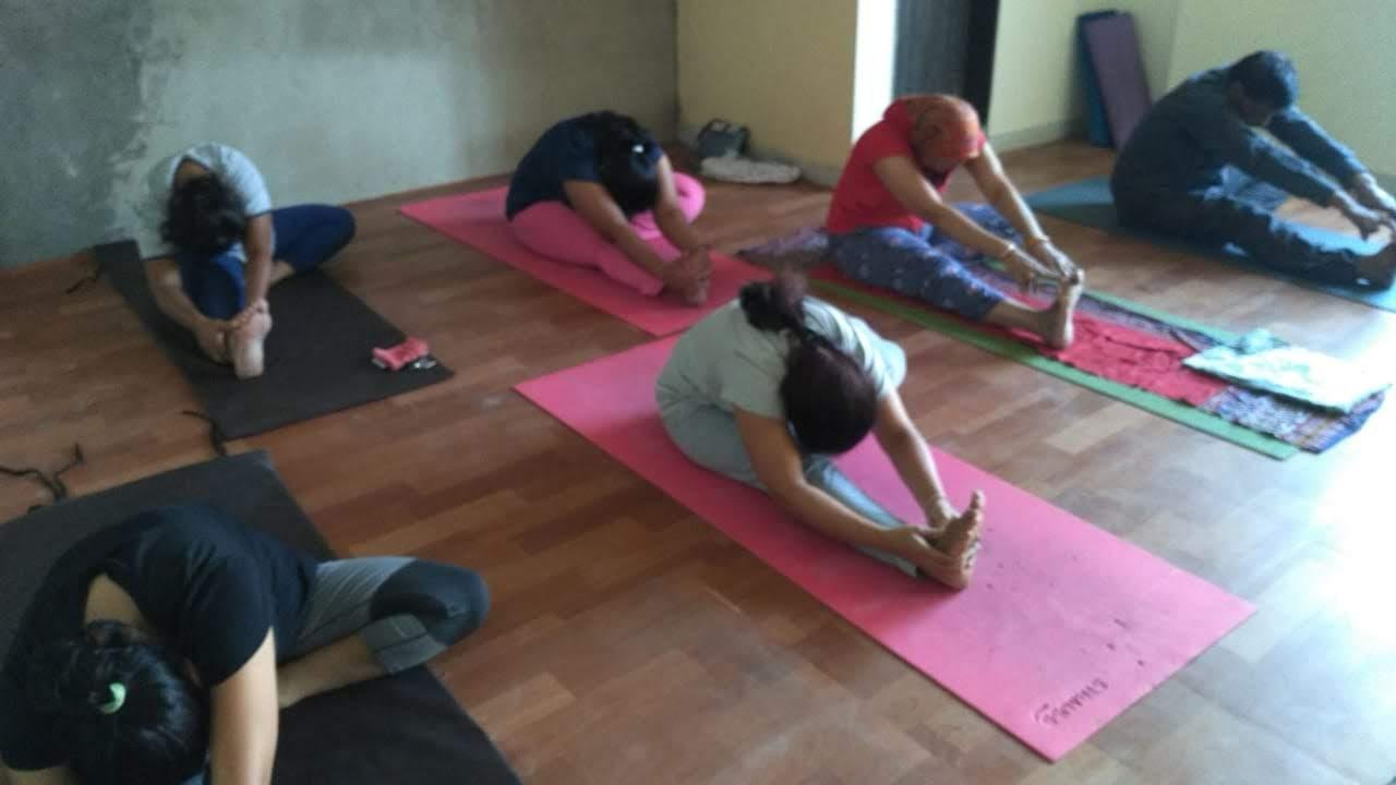 LiveFit members practicing seated forward bend poses